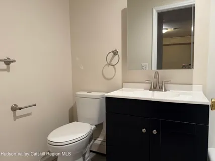 a bathroom with a sink mirror toilet and vanity
