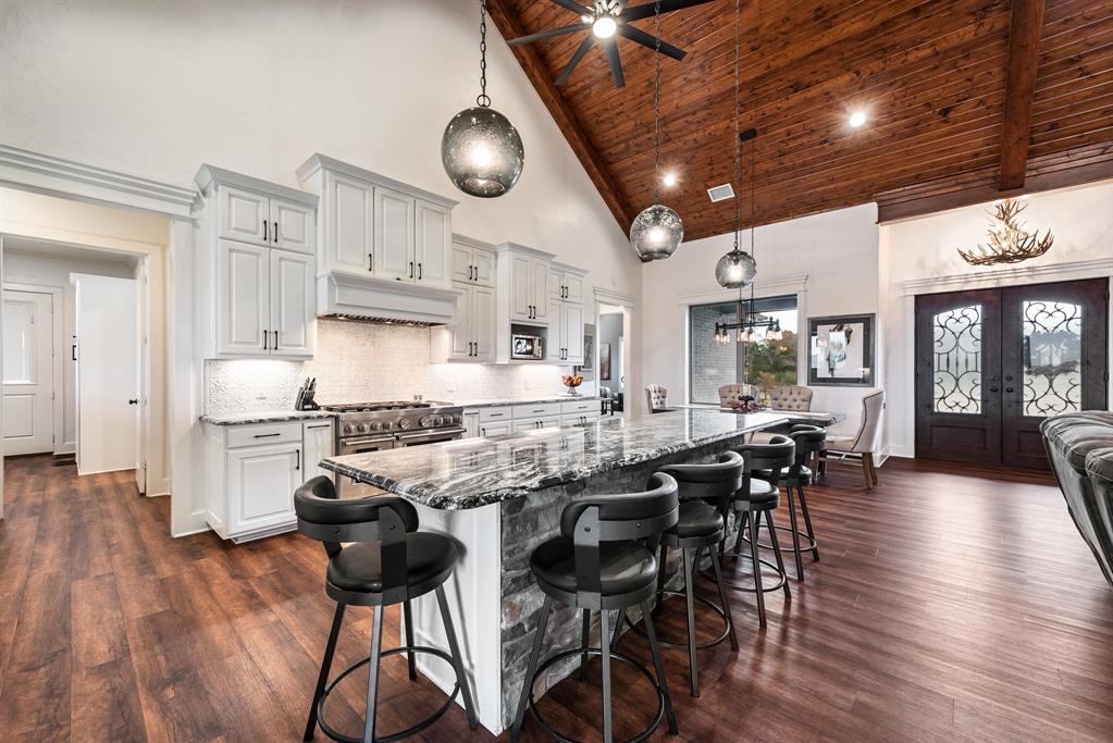 10794 County Road 334 Tyler, TX 75708 - Photo 10 of 40 a kitchen with stainless steel appliances granite countertop a stove top oven a dining table and chairs with wooden floor