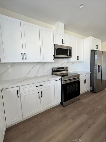 a kitchen with white cabinets and stainless steel appliances