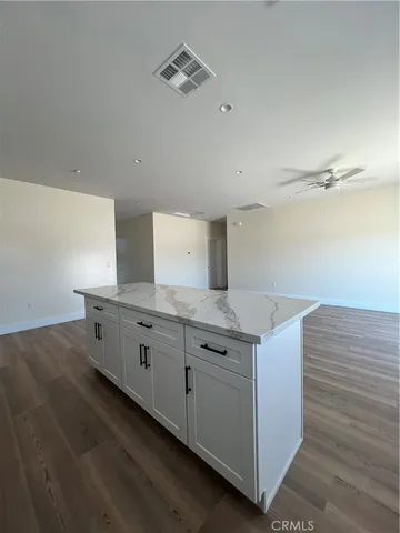 a kitchen with granite countertop white cabinets and white appliances
