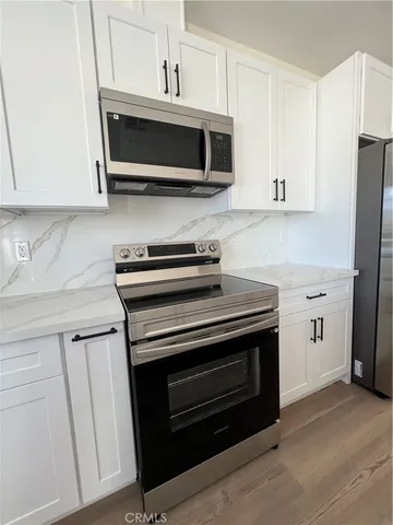 a kitchen with stainless steel appliances a stove a microwave a sink and cabinets