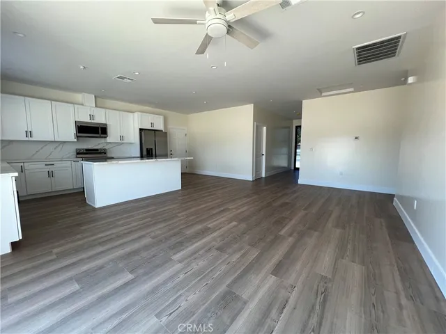 a view of a kitchen with wooden floor and a sink