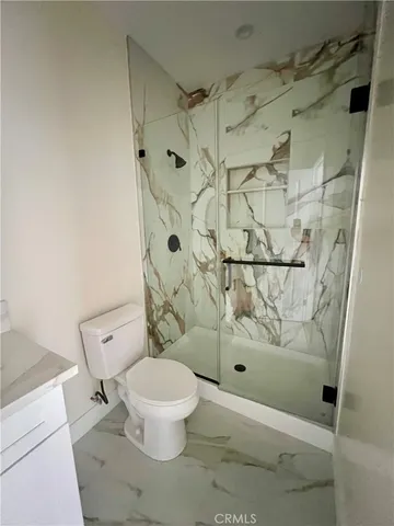 a white toilet sitting next to a shower