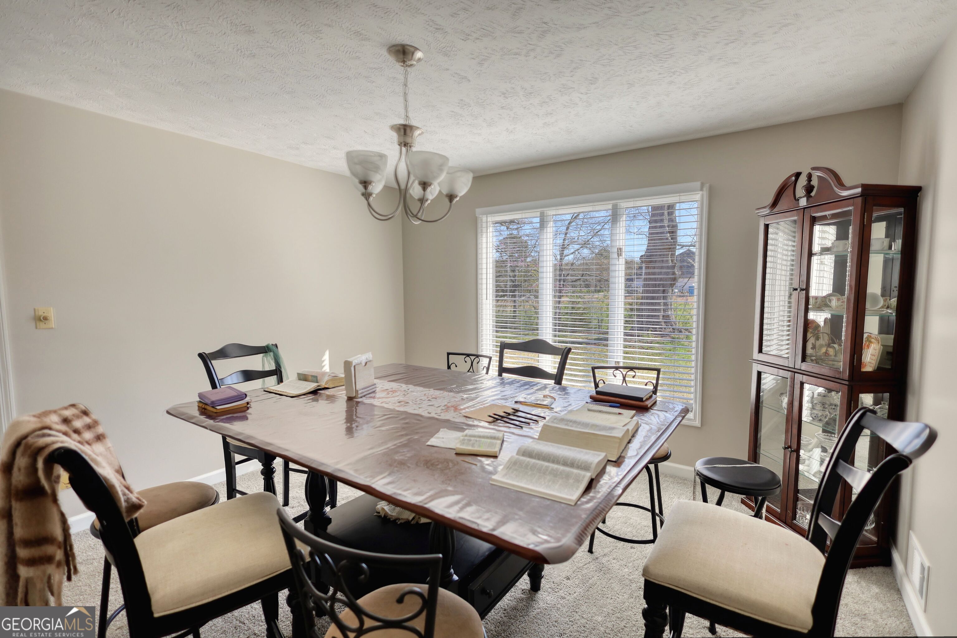 610 Loth Wages Road Dacula, GA 30019 - Photo 17 of 70 a view of a dining room with furniture wooden floor and a chandelier