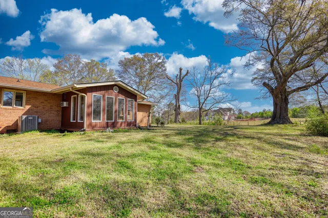 a view of a hallway with wooden floor and a dining room