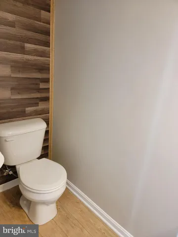 a white toilet sitting next to a white wall