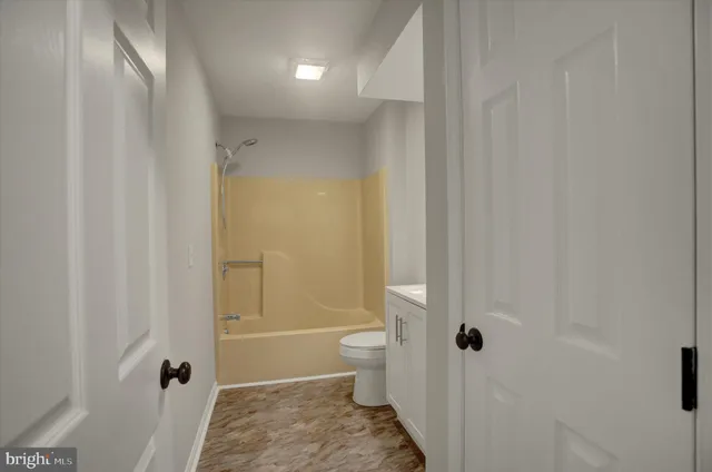 a bathroom with a granite countertop sink a toilet and shower