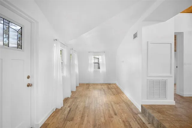 a view of a room with wooden floor closet and windows