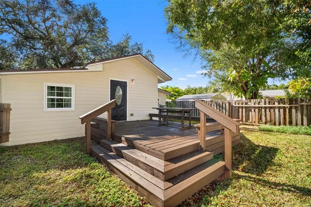 a view of a house with backyard and wooden fence