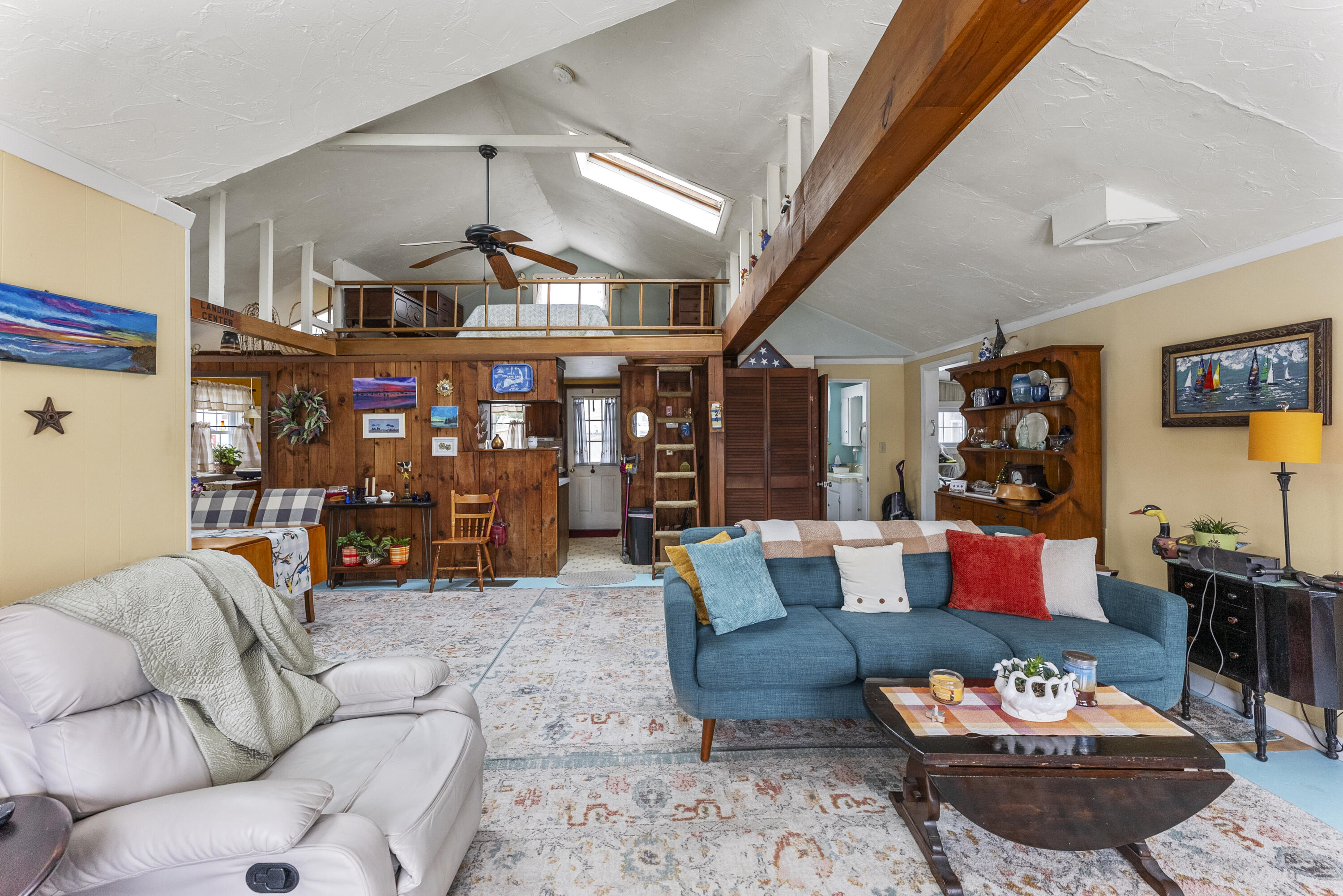 24 E Road Mashpee, MA 02649 - Photo 15 of 43 a living room with furniture a rug and a chandelier