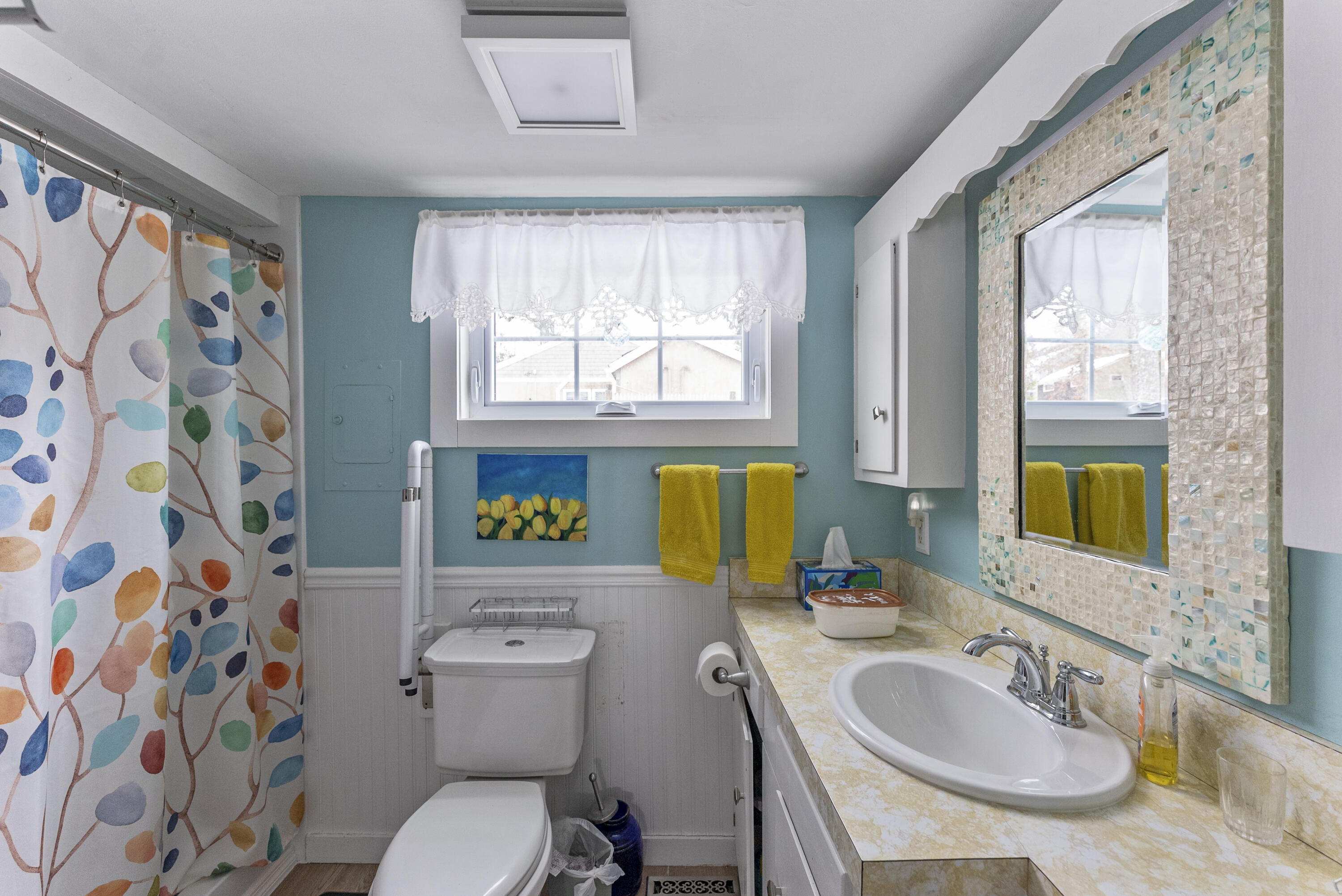 24 E Road Mashpee, MA 02649 - Photo 31 of 43 a bathroom with a sink a toilet a window and shower curtain