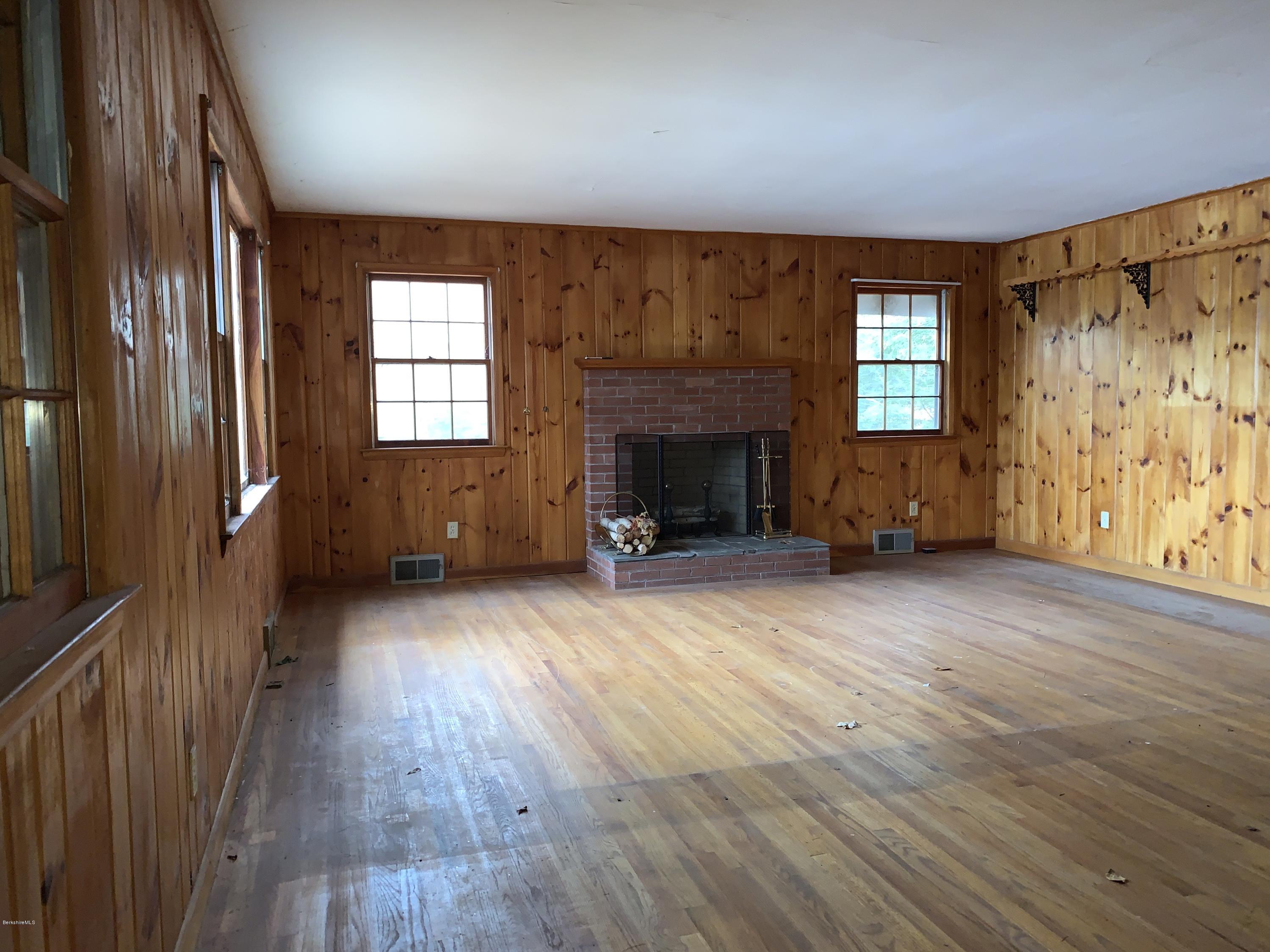 21 Point Road Monterey, MA 01245 - Photo 8 of 25 an empty room with windows a fireplace and wooden floor