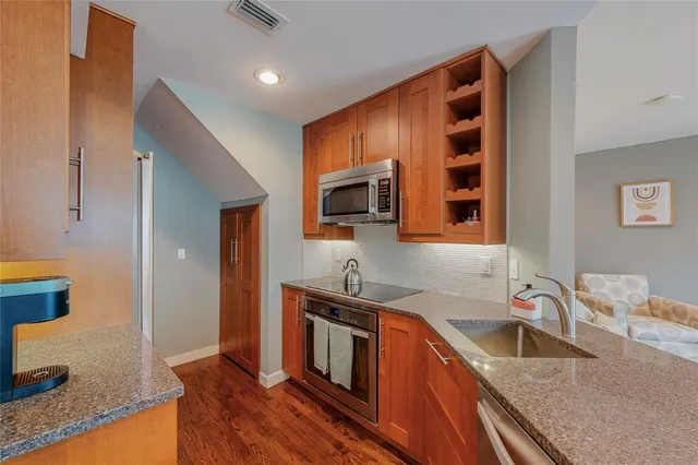 a kitchen with granite countertop a sink stove and microwave