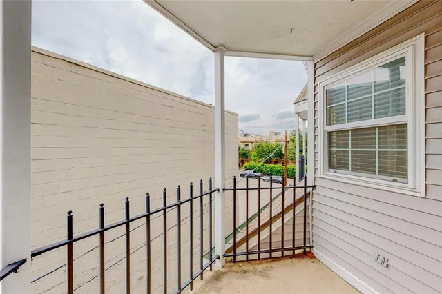 a view of a balcony with a floor to ceiling window and wooden fence