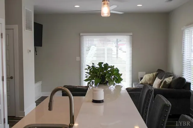 a dining room with furniture and potted plants
