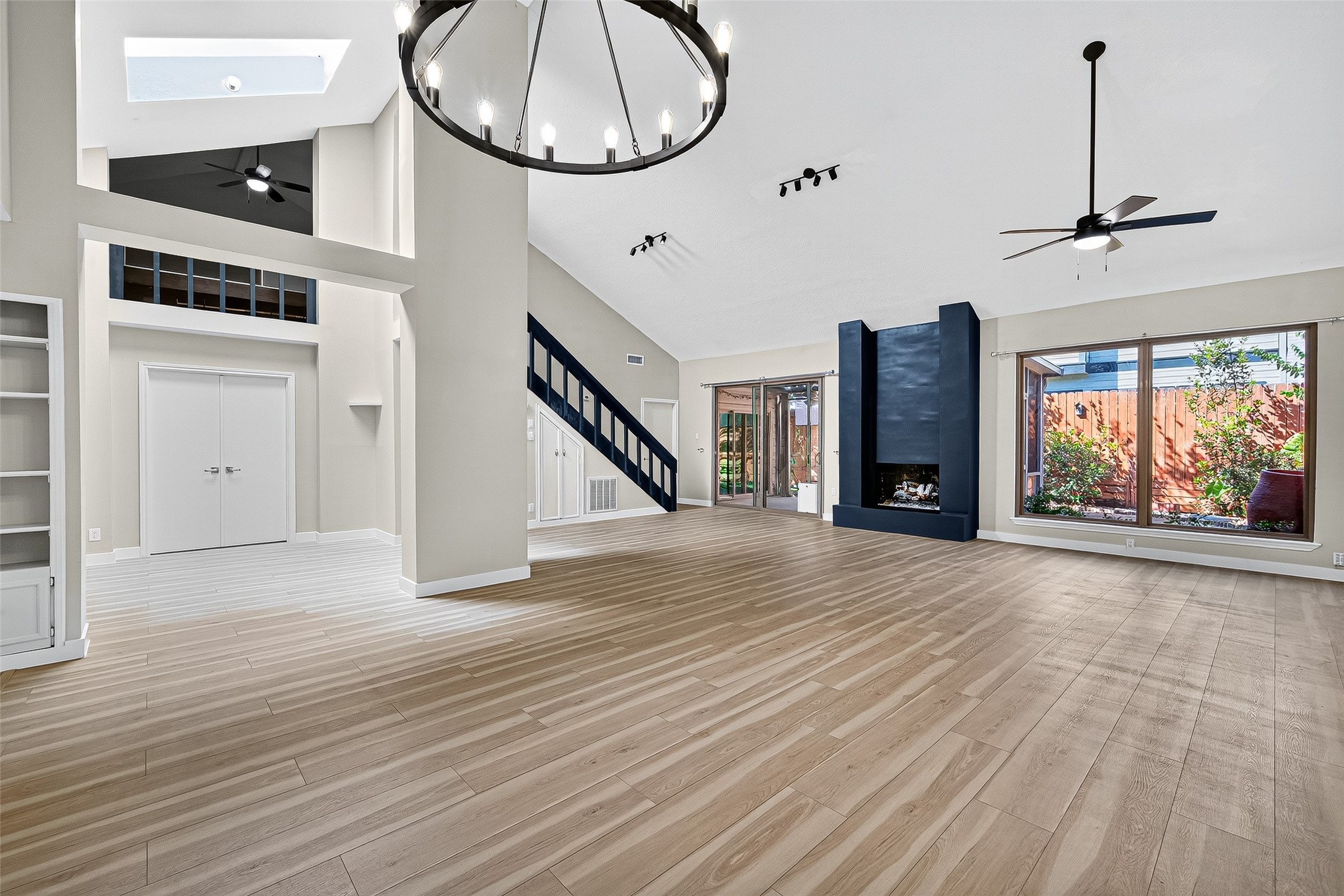 2026 Ashford Hollow Lane Houston, TX 77077 - Photo 35 of 35 an empty room with a fireplace and lots of wooden floor