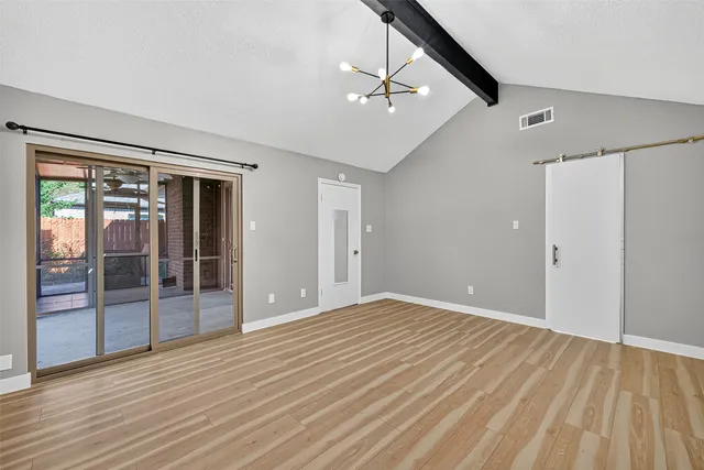 a view of an empty room with wooden floor