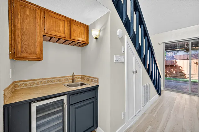 a view of an empty room with wooden floor and a ceiling fan