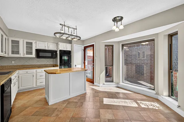 a view of a hallway with wooden floor and windows