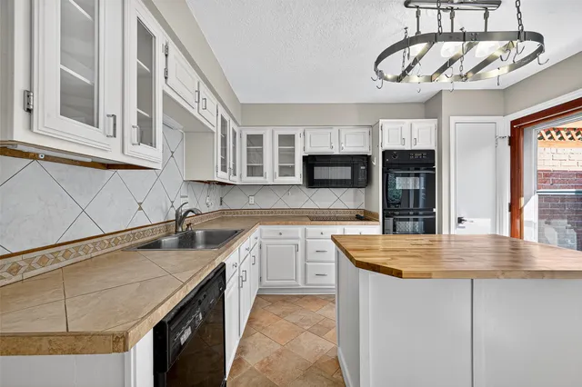 a kitchen with stainless steel appliances granite countertop a sink a stove and cabinets
