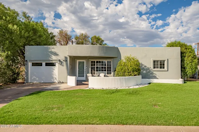 a front view of a house with a yard and sitting area
