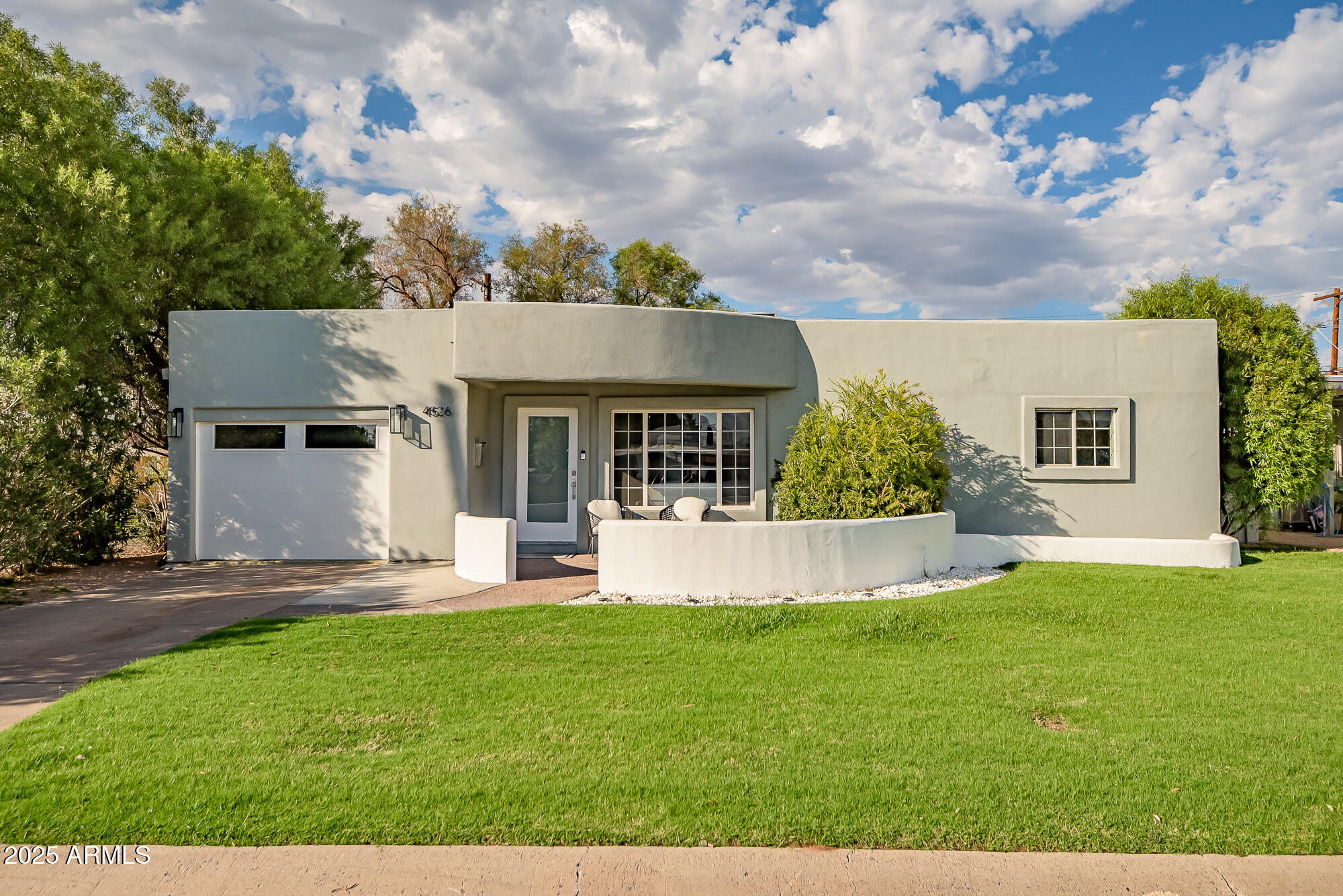a front view of a house with a yard and sitting area