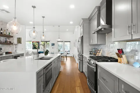 a kitchen with kitchen island granite countertop a sink a counter space appliances and cabinets