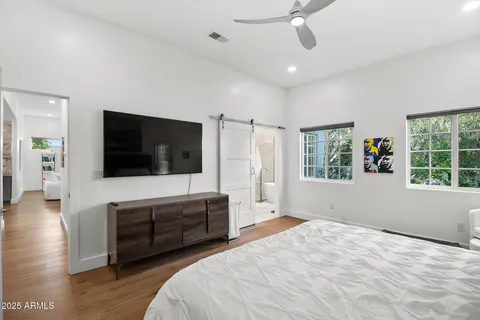 a spacious bedroom with a large bed and a flat screen tv