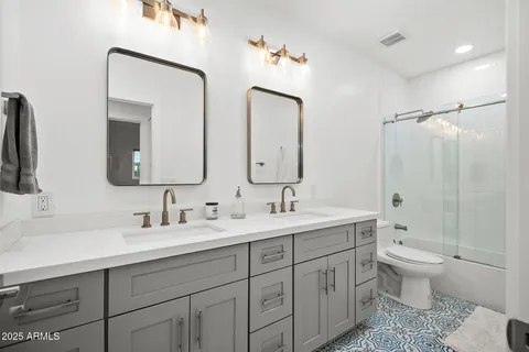 a bathroom with a double vanity sink mirror and toilet