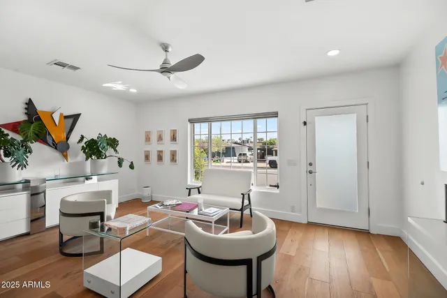 a living room with furniture and a wooden floor