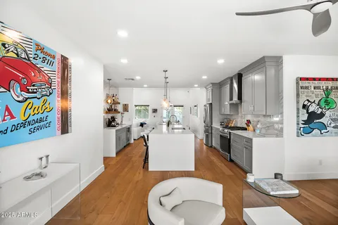 a living room with stainless steel appliances kitchen island granite countertop furniture a rug and white walls
