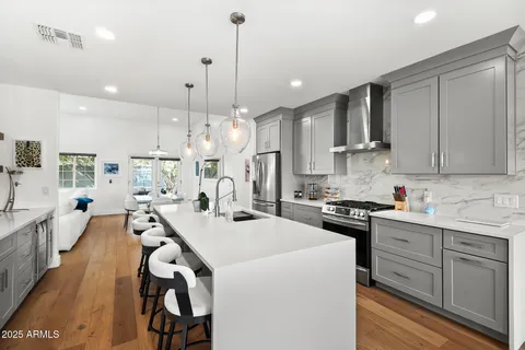 a kitchen with stainless steel appliances kitchen island a stove a sink a center island and a cabinets