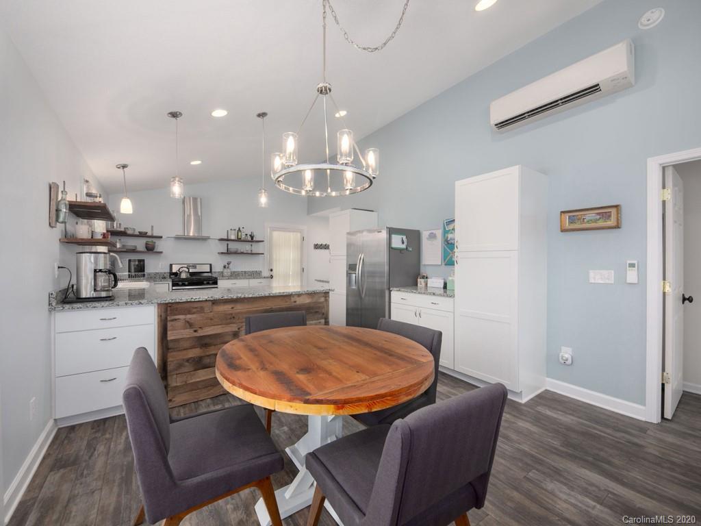 249 Bane Road Mills River, NC 28759 - Photo 20 of 30 a kitchen with stainless steel appliances kitchen island granite countertop a dining table chairs and a refrigerator