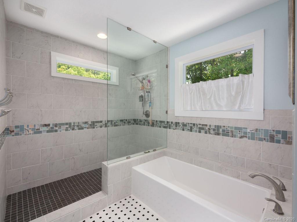 249 Bane Road Mills River, NC 28759 - Photo 27 of 30 a bathroom with a bathtub a window and a shower