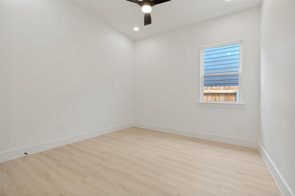1143 Riverwood Road Dallas, TX 75217 - Photo 16 of 24 Interior room featuring light wood-finish flooring, white walls, and bright white trim