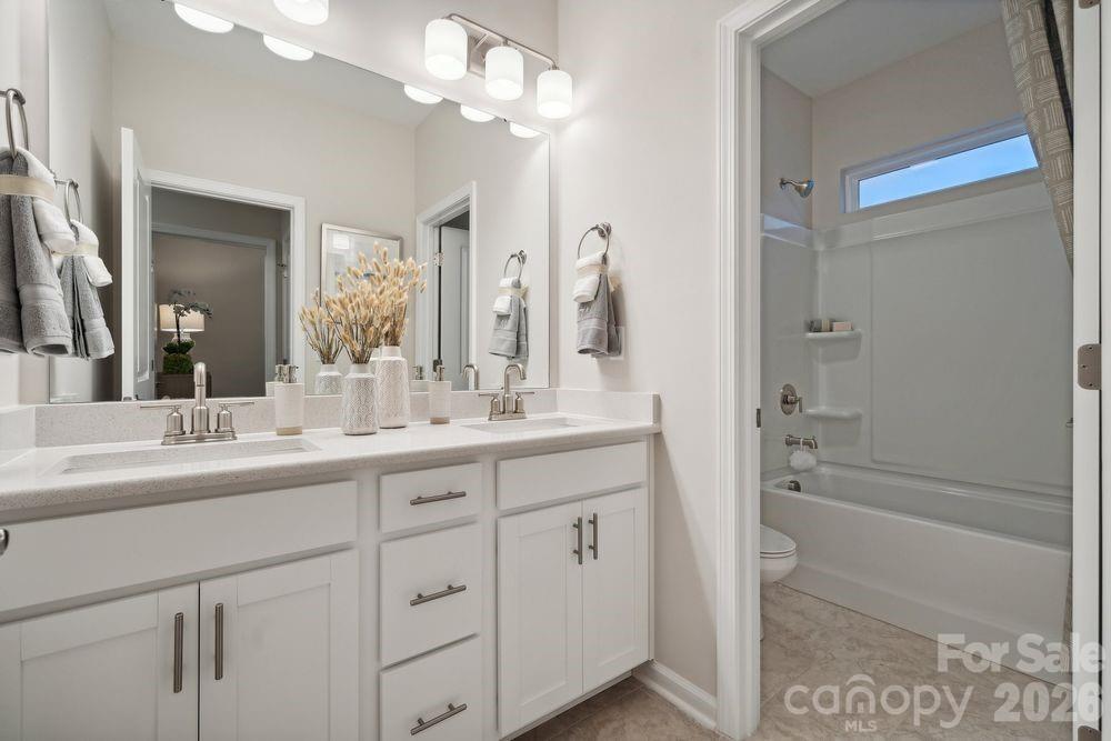 8671 Miles Gap Road Indian Land, SC 29707 - Photo 19 of 31 a bathroom with a double vanity sink a mirror and a bathtub