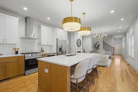 a kitchen with a dining table chairs sink and white cabinets