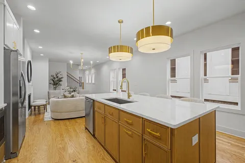 a kitchen with a refrigerator a sink and living room view