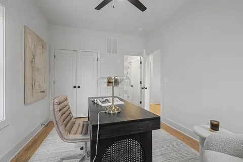 a view of a workspace with furniture and wooden floor