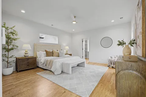 a spacious bedroom with a bed couch and a dresser