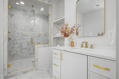 a bathroom with a shower sink and a mirror