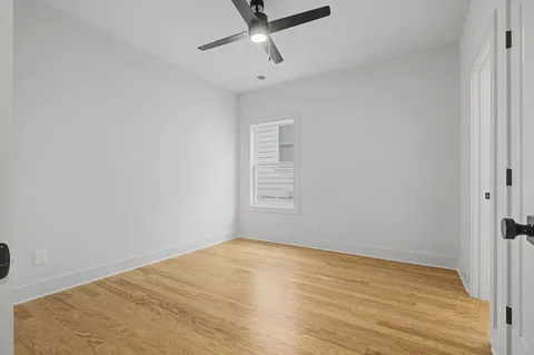 a view of a room with wooden floor and a ceiling fan