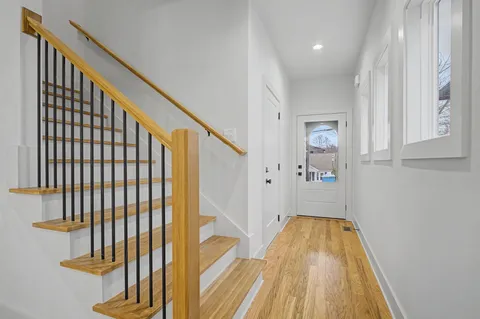 a view of a hallway with wooden floor and staircase