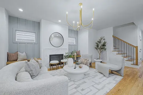 a living room with furniture chandelier and a fireplace