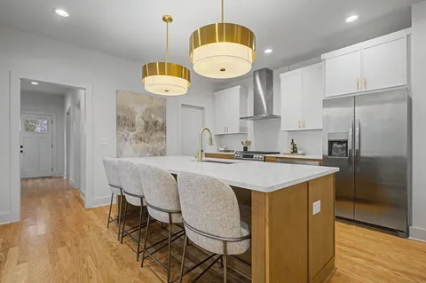 a kitchen with kitchen island granite countertop a sink a center island and stainless steel appliances