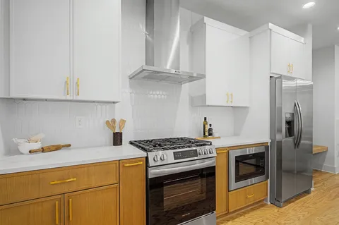 a kitchen with stainless steel appliances granite countertop a sink stove and refrigerator