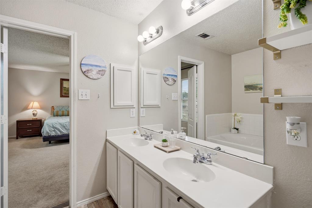 1213 Hampton Drive Forney, TX 75126 - Photo 18 of 27 a en suite bathroom with a double vanity sink and a mirror