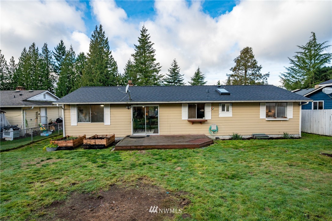 9211 3rd Place Southeast Everett, WA 98208 - Photo 28 of 33 a front view of a house with a garden and trees