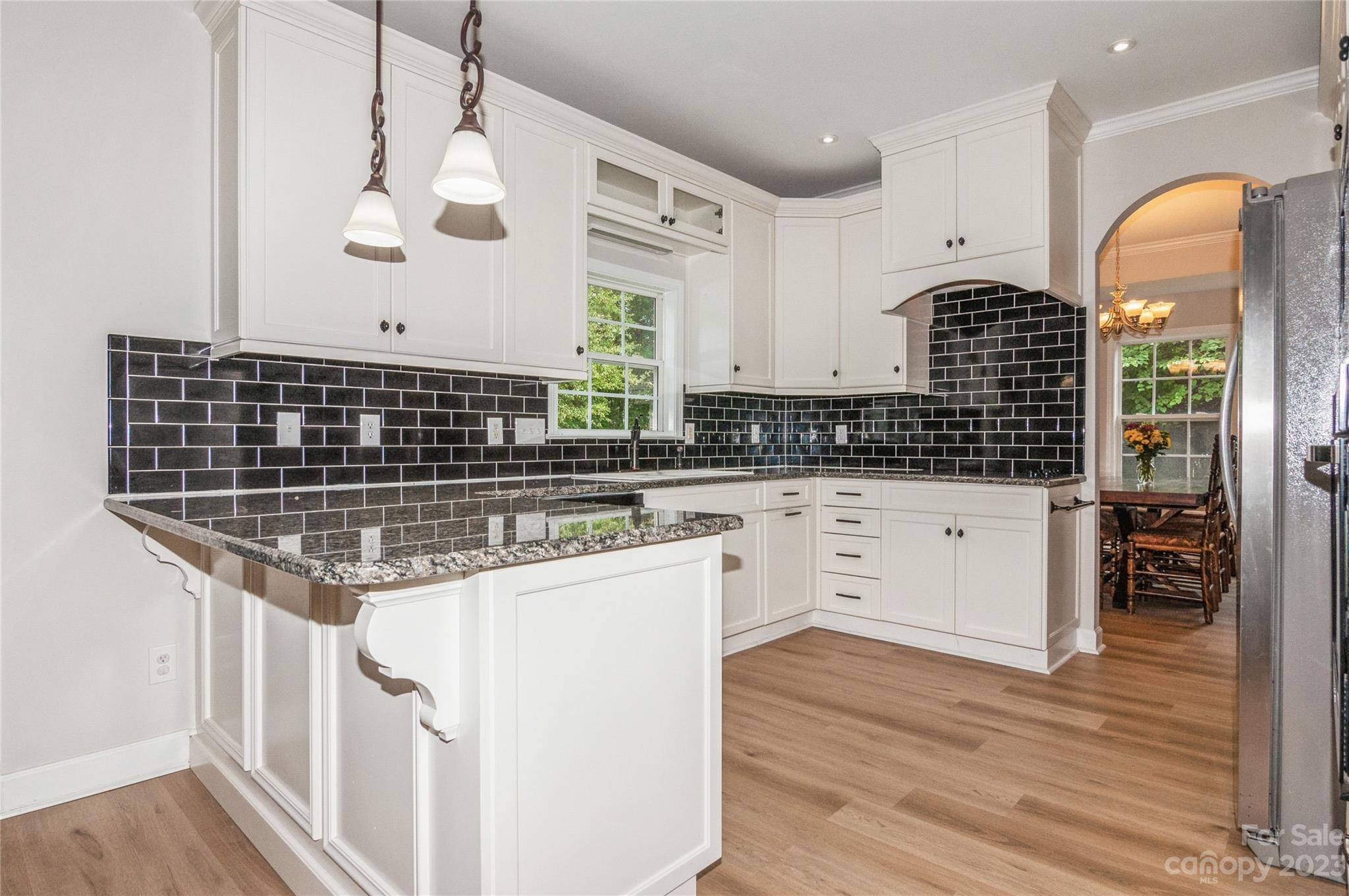 4227 Flint Drive Lancaster, SC 29720 - Photo 9 of 39 a kitchen with granite countertop a stove a sink and white cabinets with wooden floor