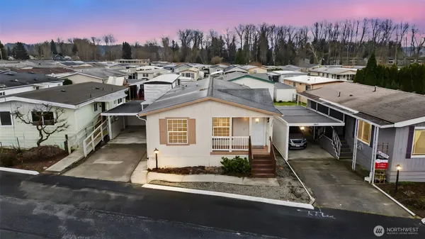 a view of a house with a yard and a car parked